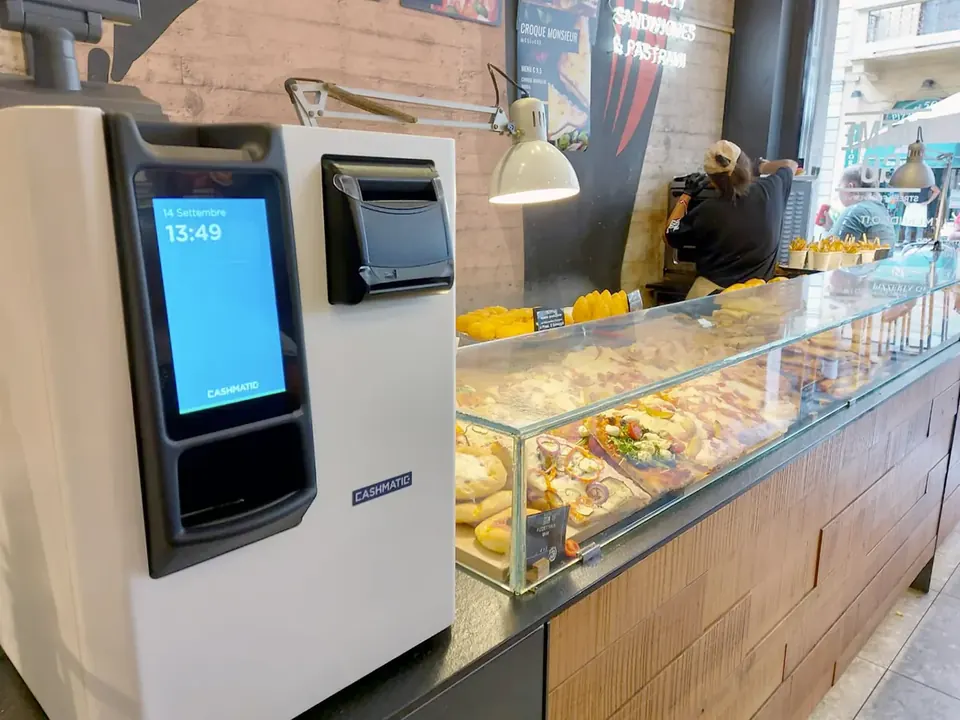 Monnayeur automatique posé au bout de la vitrine d'une boulangerie